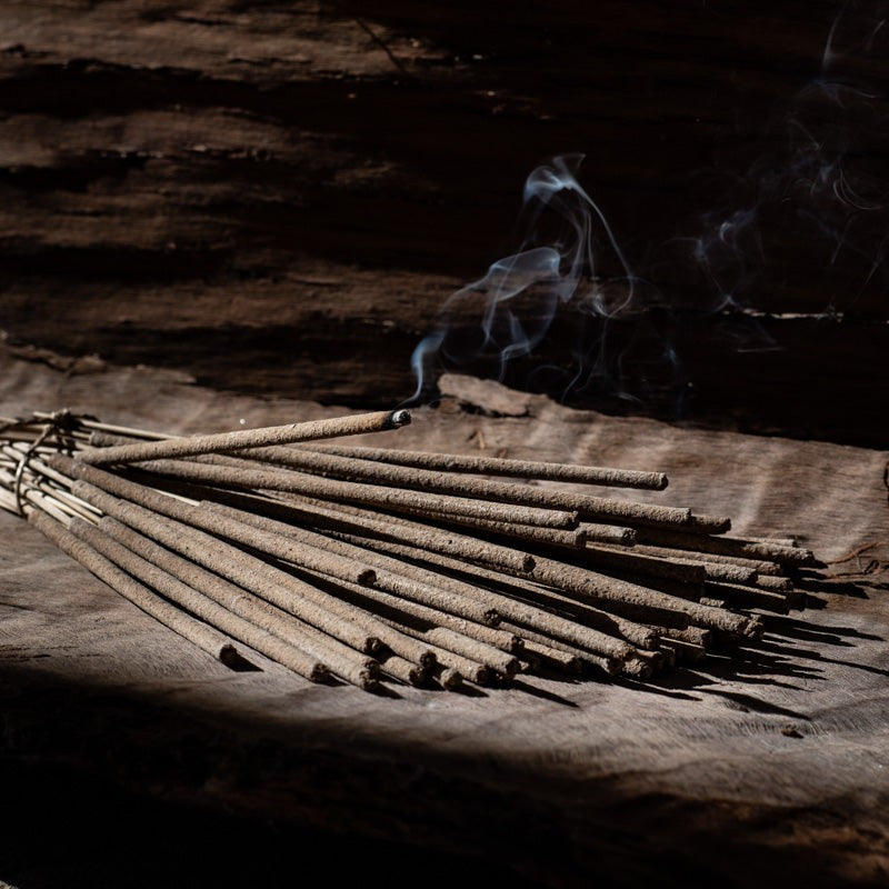 Frankincense incense sticks burning on a wooden board