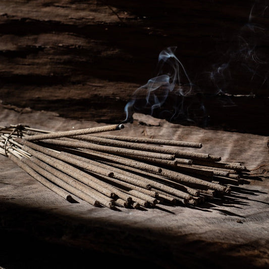 Frankincense incense sticks burning on a wooden board